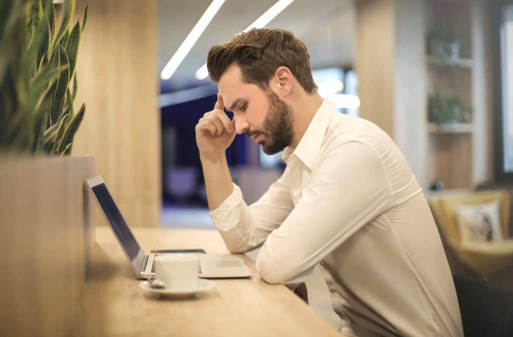 man looking at computer in deep thought