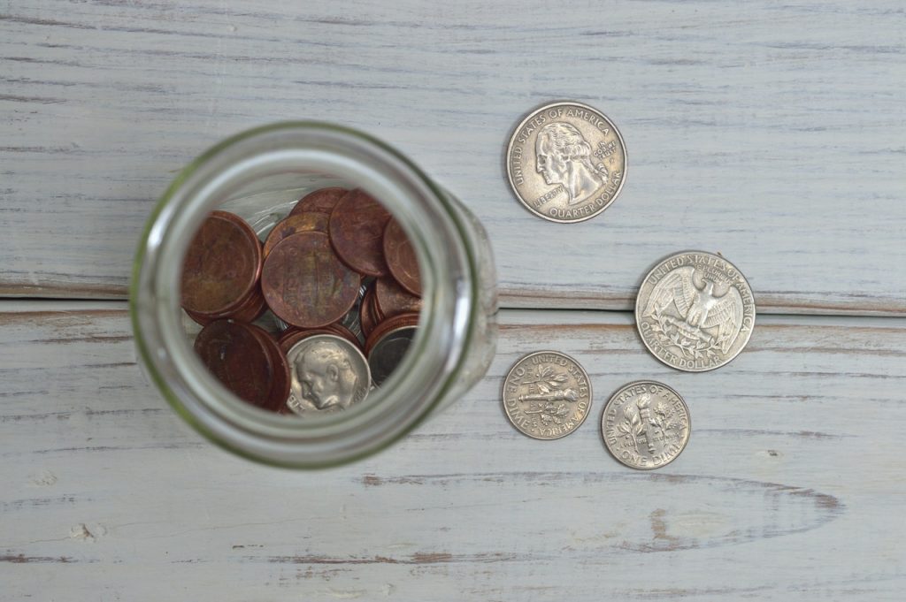 coins inside a jar and some beside it